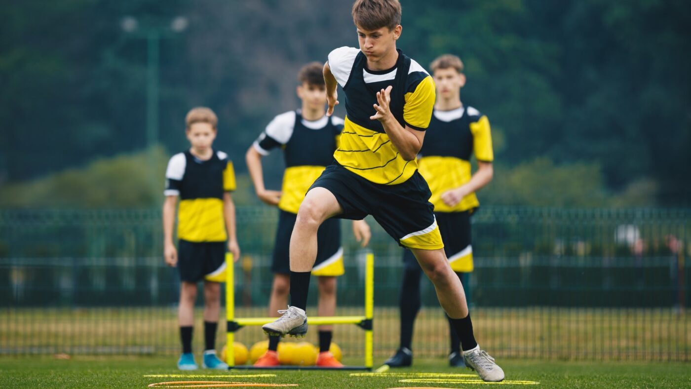 Jeunes footballeurs travaillant leur agilité sur un terrain