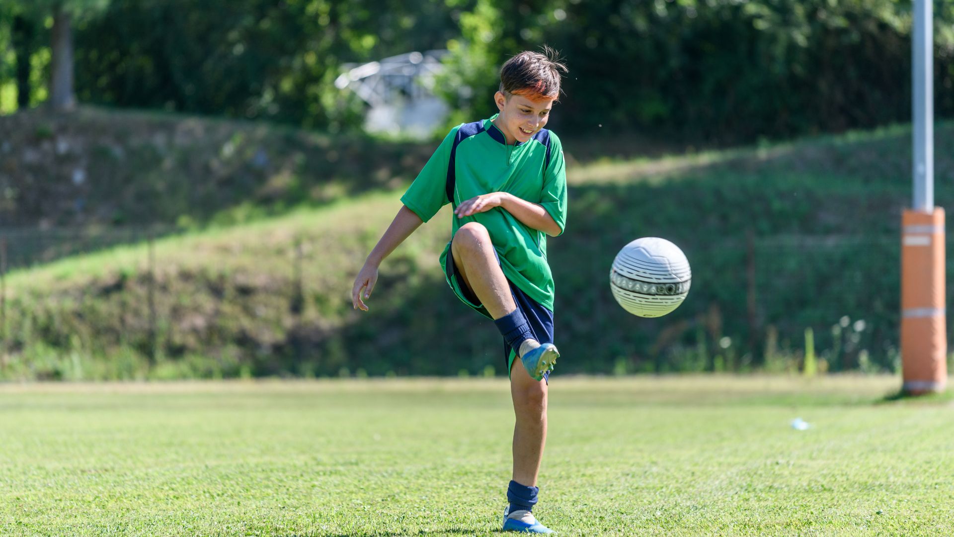 Un jeune joueur contrôlant le ballon sur un terrain de football