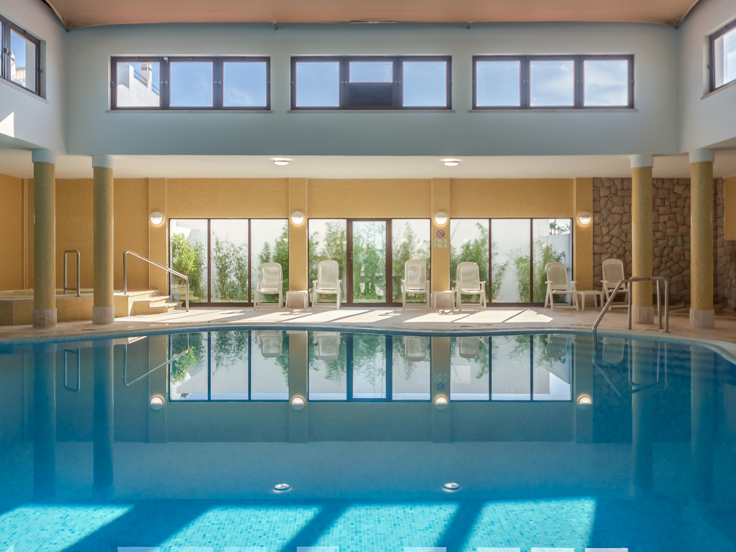 Bassin couvert et baies vitrées de la piscine intérieure du Golden Club Cabanas
