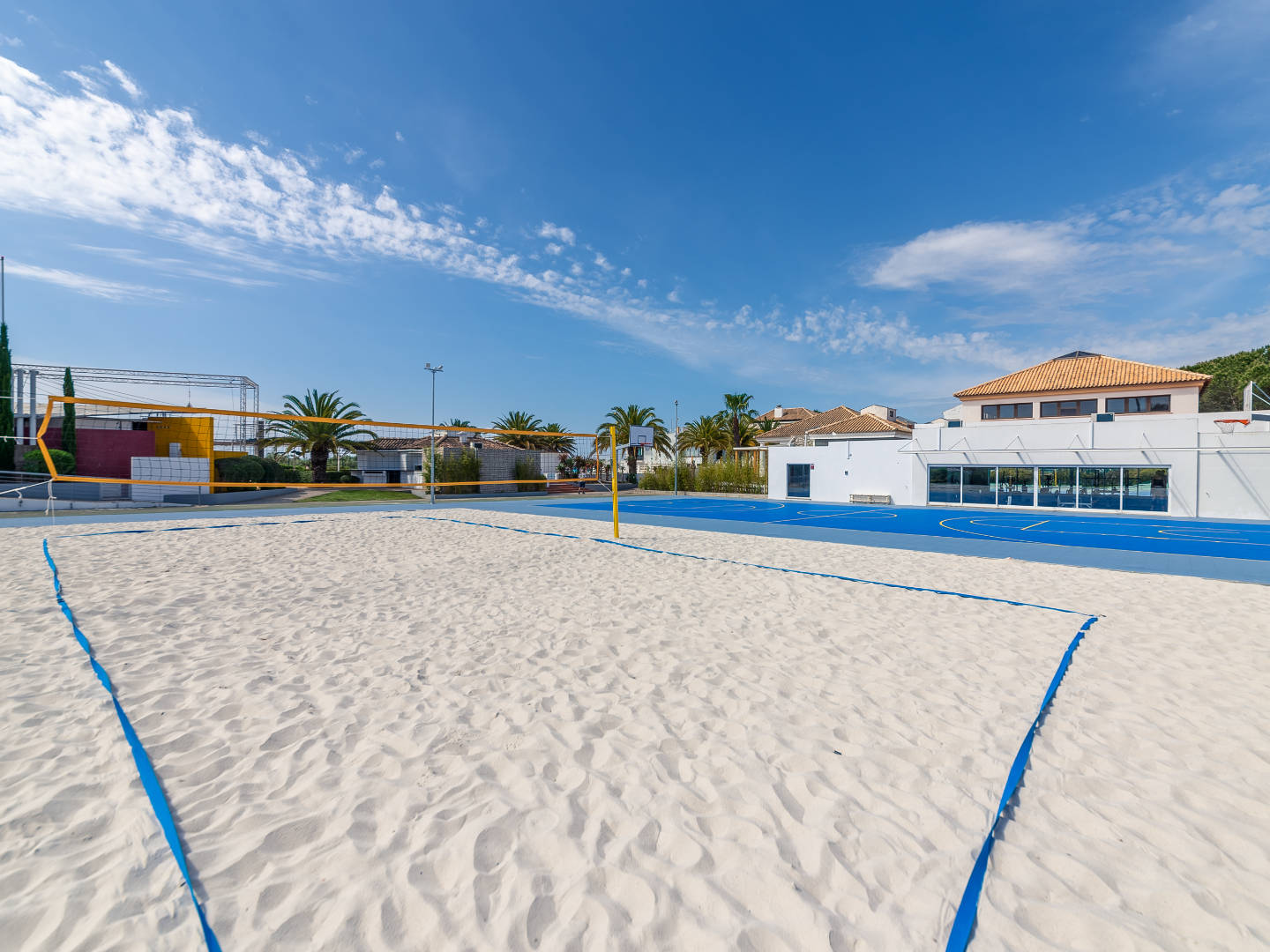 Terrain de beach-volley sur sable et terrain multisport bleu avec paniers de basket au Golden Club Cabanas